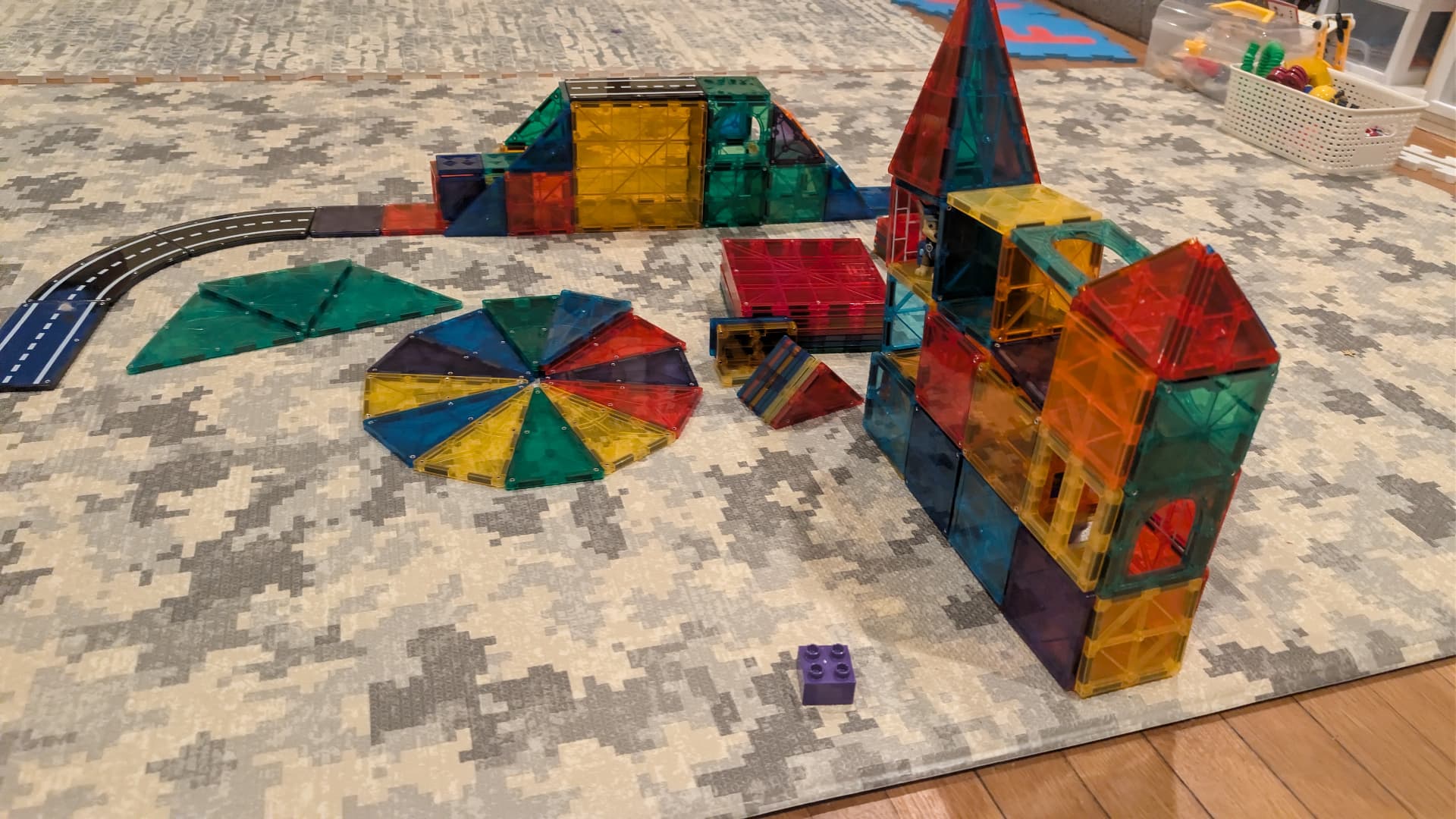 Magna-Tiles built into colorful houses and shapes on a living room rug